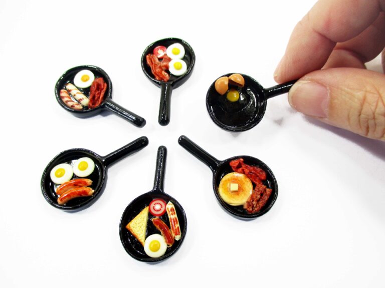 Main collection of 1:12 scale dollhouse miniature breakfast frying pans with eggs, bacon, pancakes, and sausages on white background.