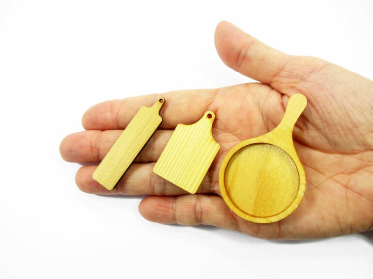 Handcrafted 1:12 scale miniature wood serving paddle boards in square, round, and long shapes held on a palm for display.